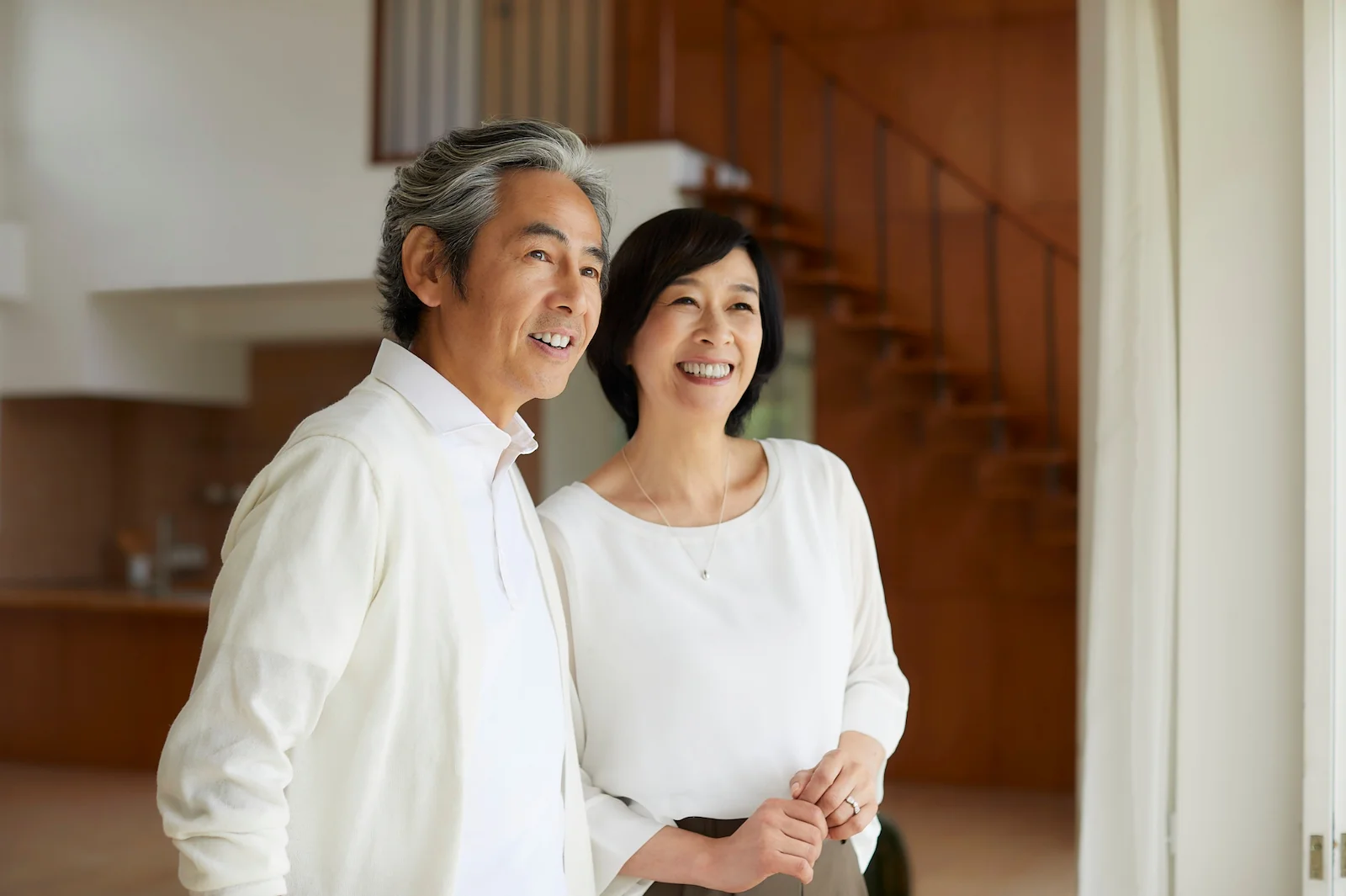Smiling senior couple standing together in their bright, modern home
