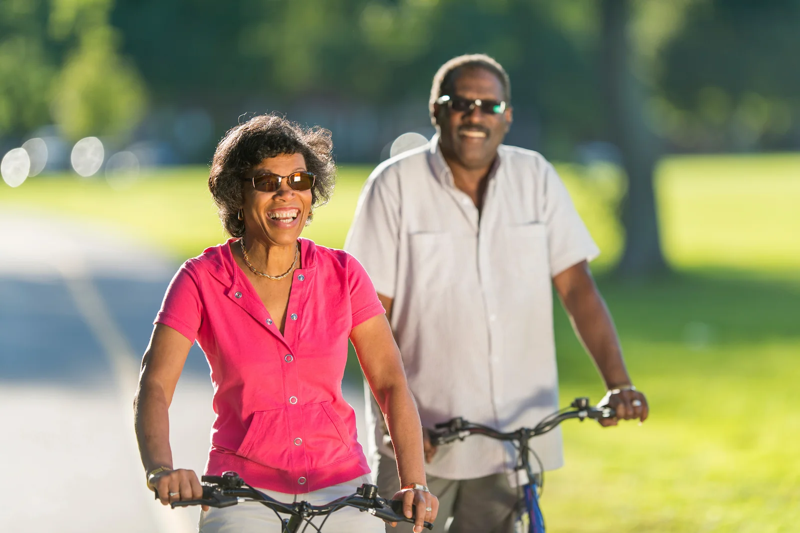 Active senior couple riding bikes together on a sunny day in the park