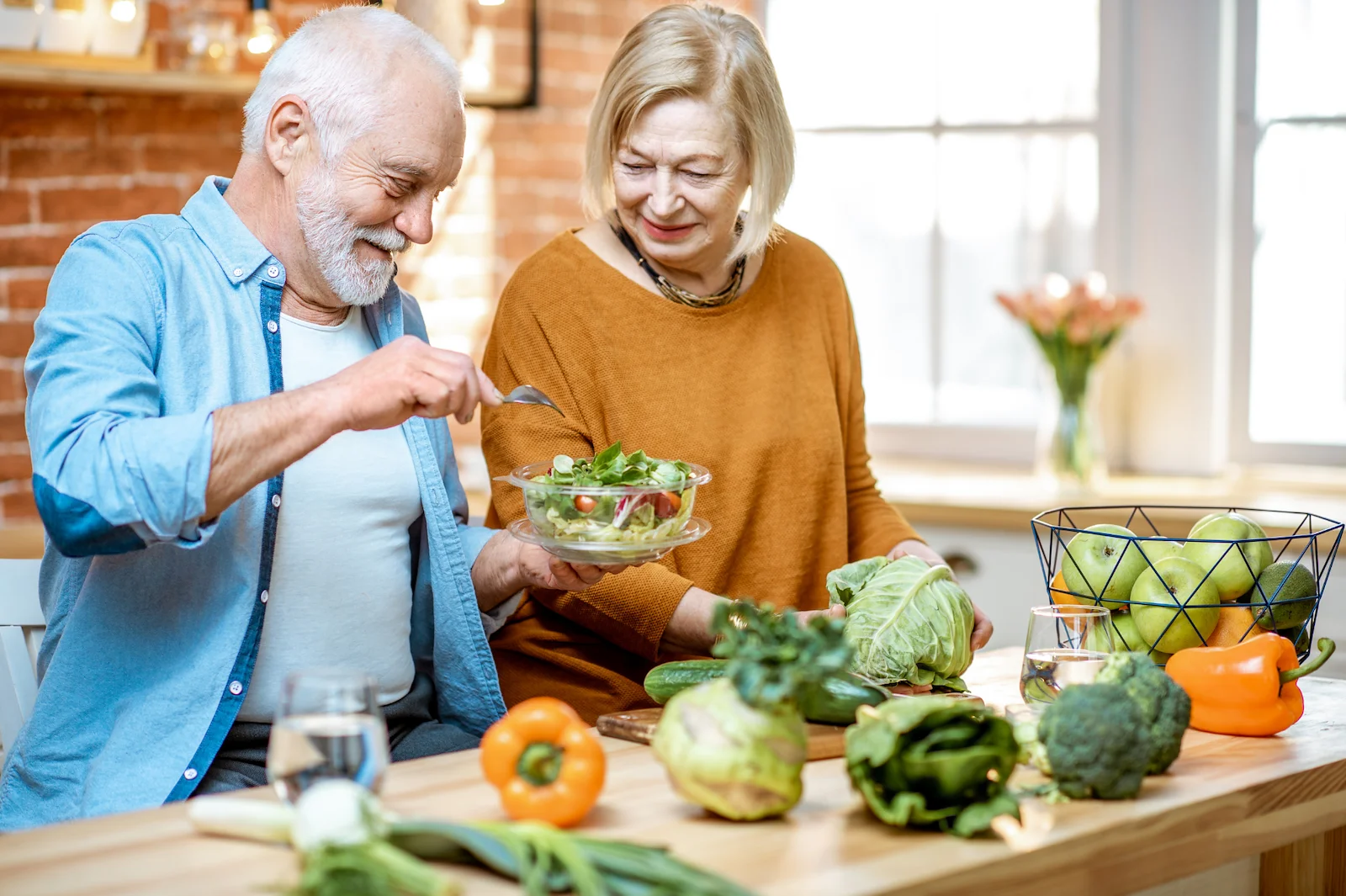 Senior couple preparing a healthy salad together in a modern kitchen
