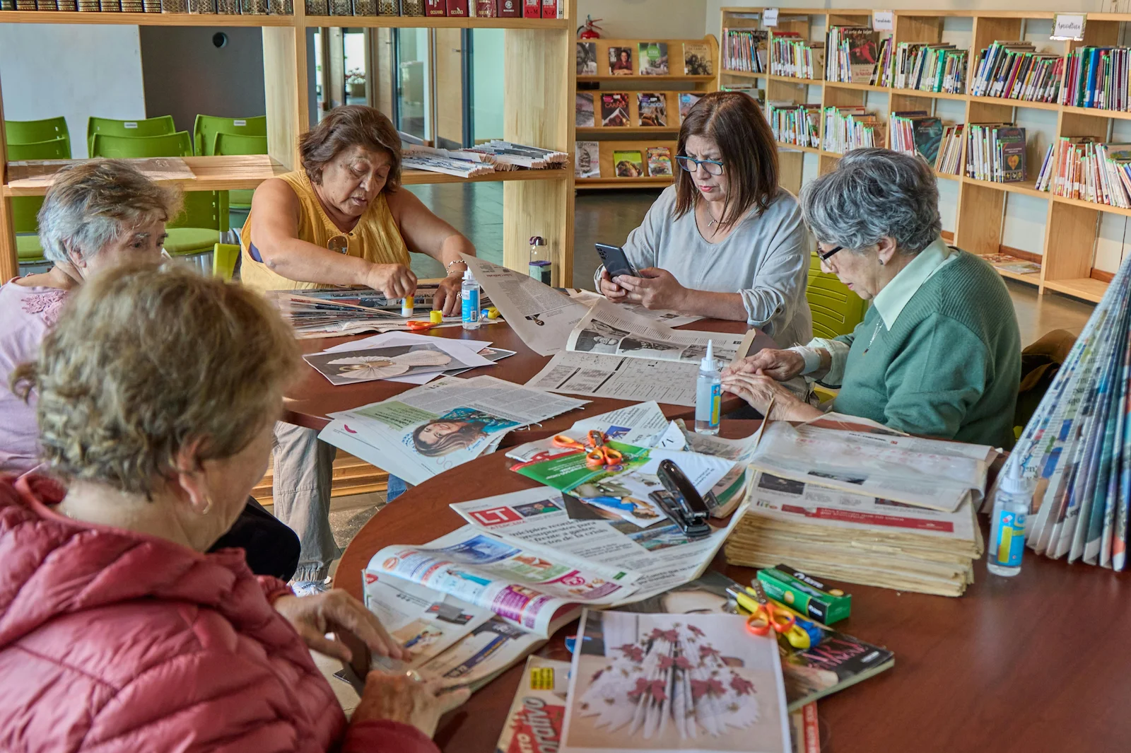 Group of seniors working on arts and crafts projects in a library activity room