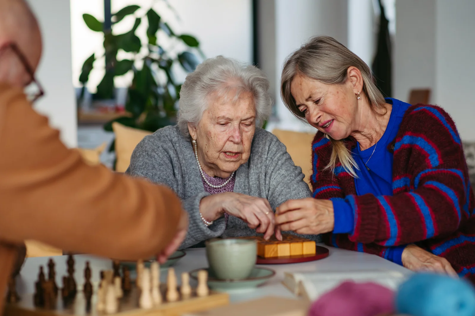 Senior women engaged in a puzzle activity together at a care facility