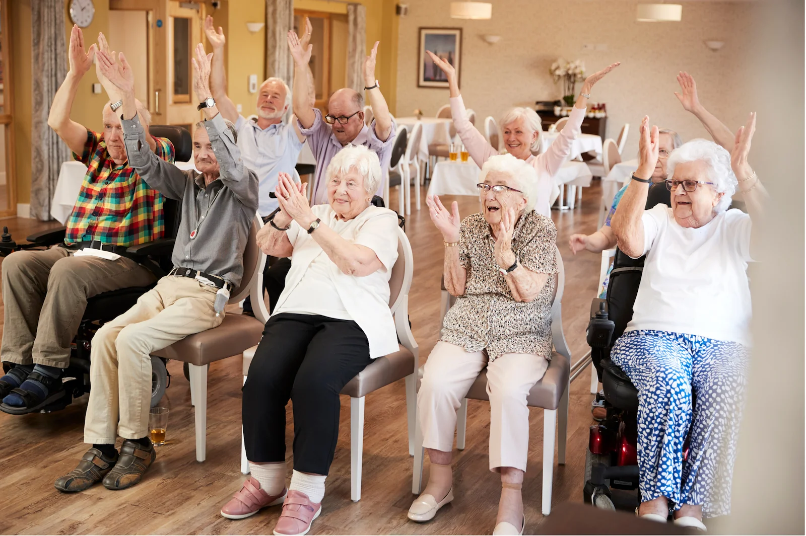 Group of happy seniors participating in a chair exercise class at assisted living near you