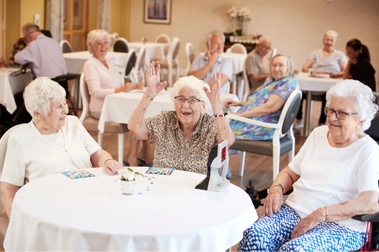 Seniors celebrating a bingo win together in a community dining room
