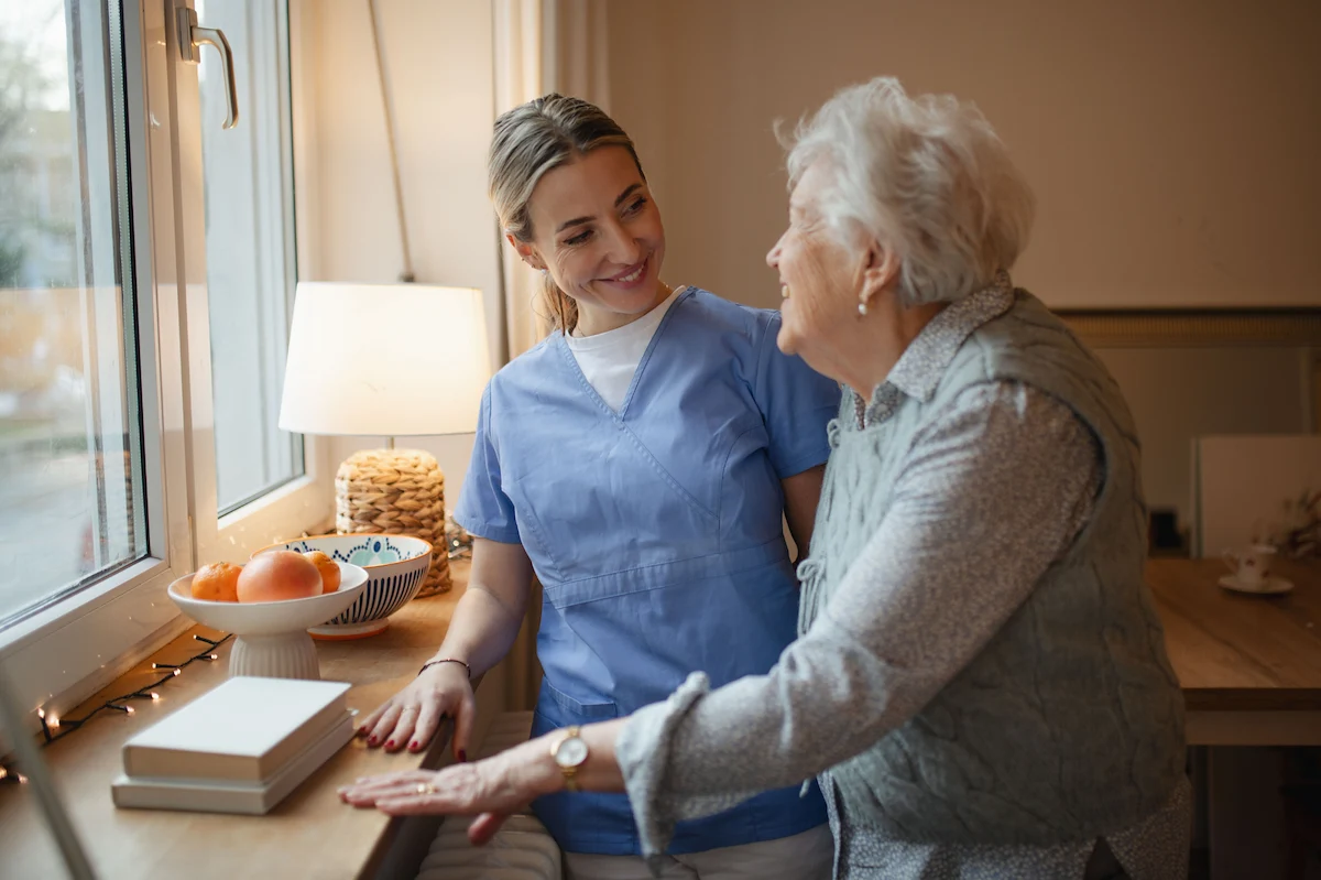 Caregiver providing compassionate home care near you to senior woman in a bright kitchen