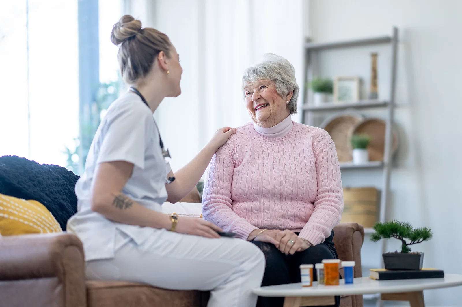 Healthcare worker consulting with senior woman about medications at home