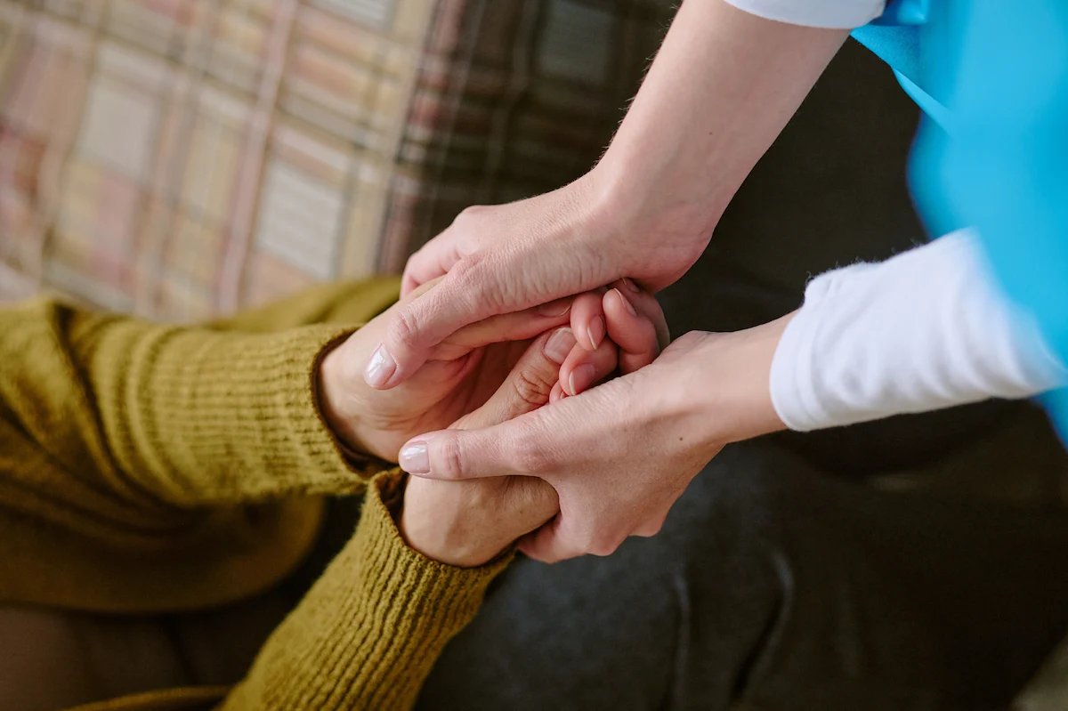 Hospice caregiver providing comfort to patient