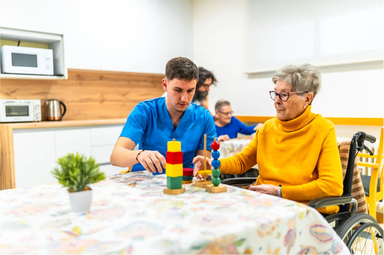 Care staff engaging resident in cognitive therapy with building blocks