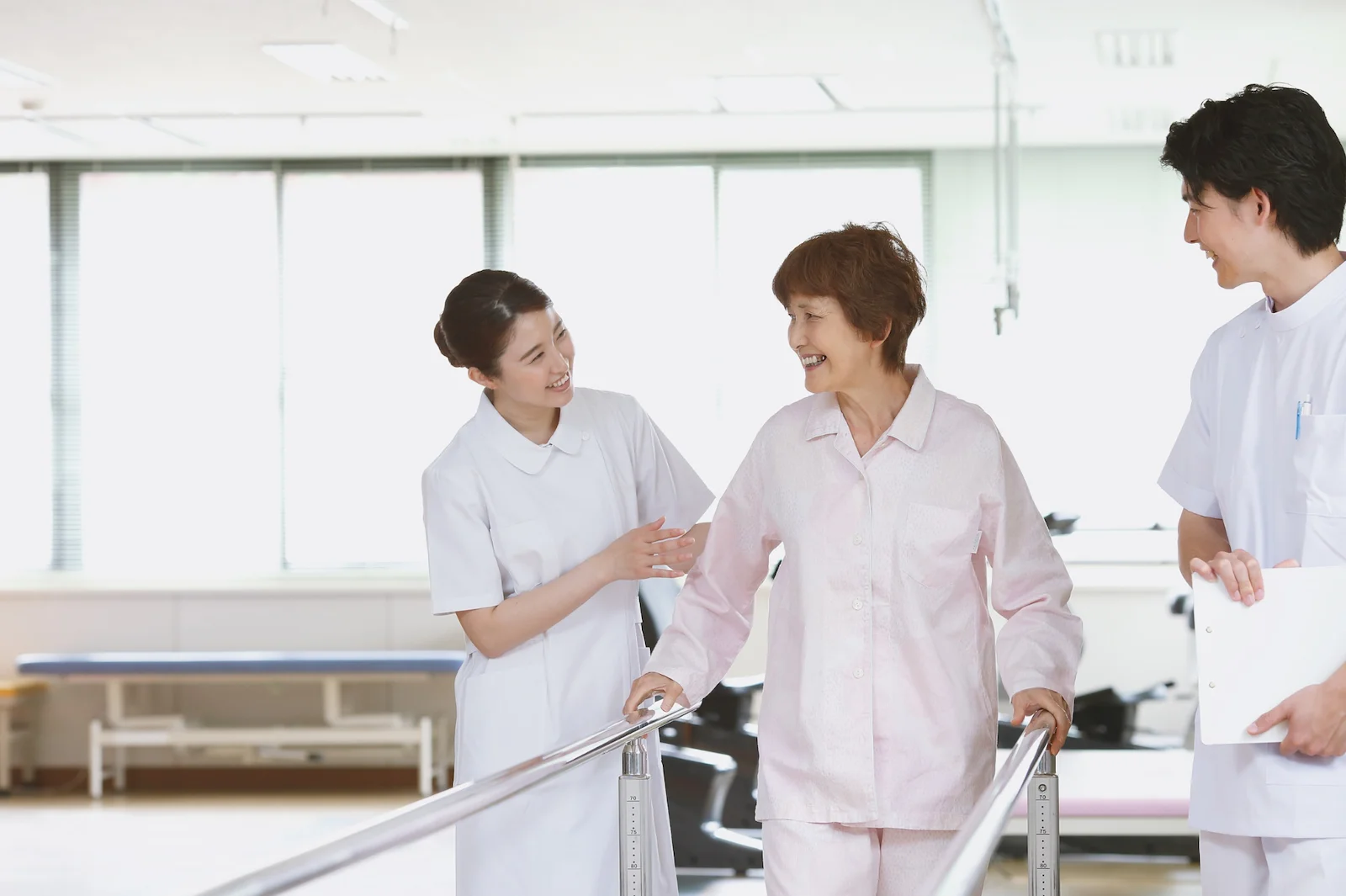 Healthcare team supporting senior with physical therapy walking exercises