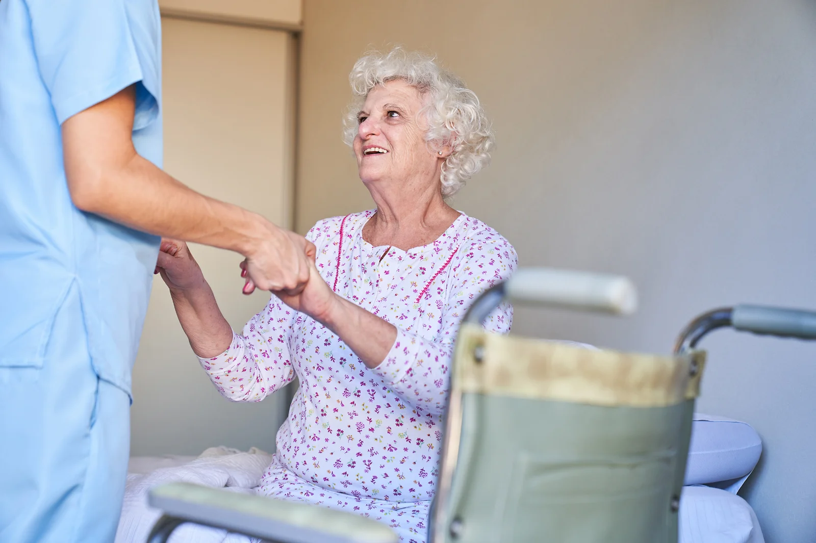Nurse assisting joyful senior with mobility and daily activities