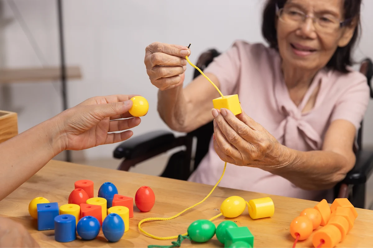 Senior engaging in fine motor skills activity during therapy session