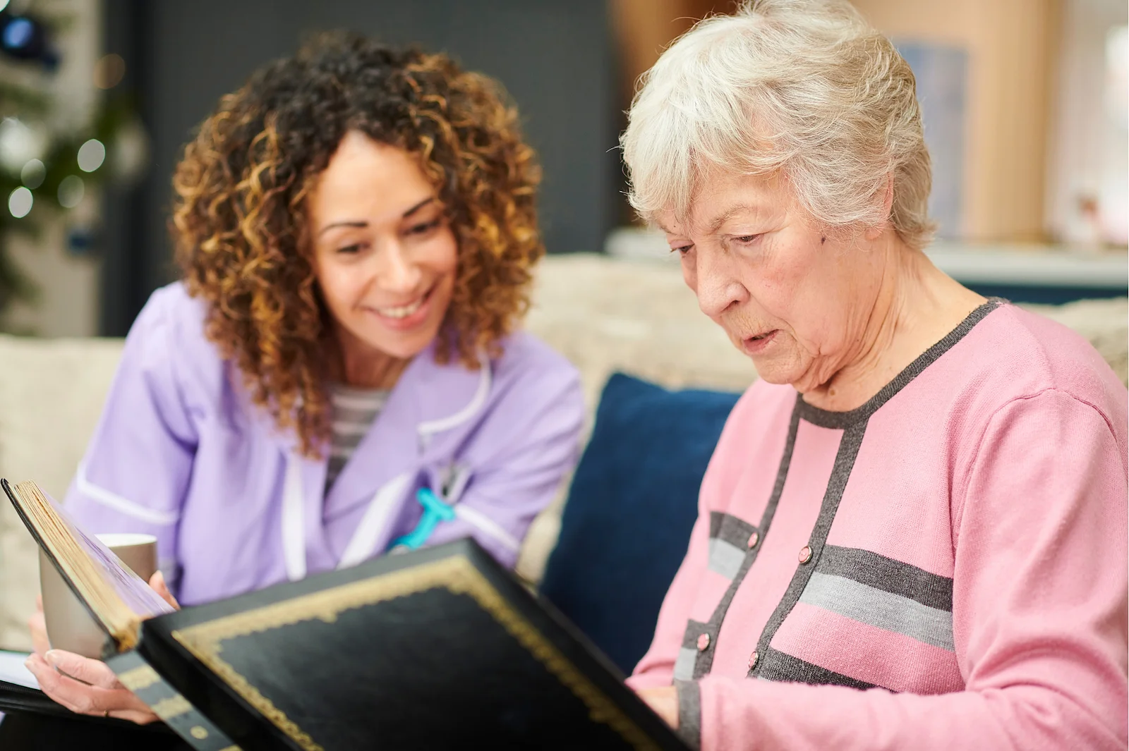 Caregiver reading with senior resident during a memory care activity