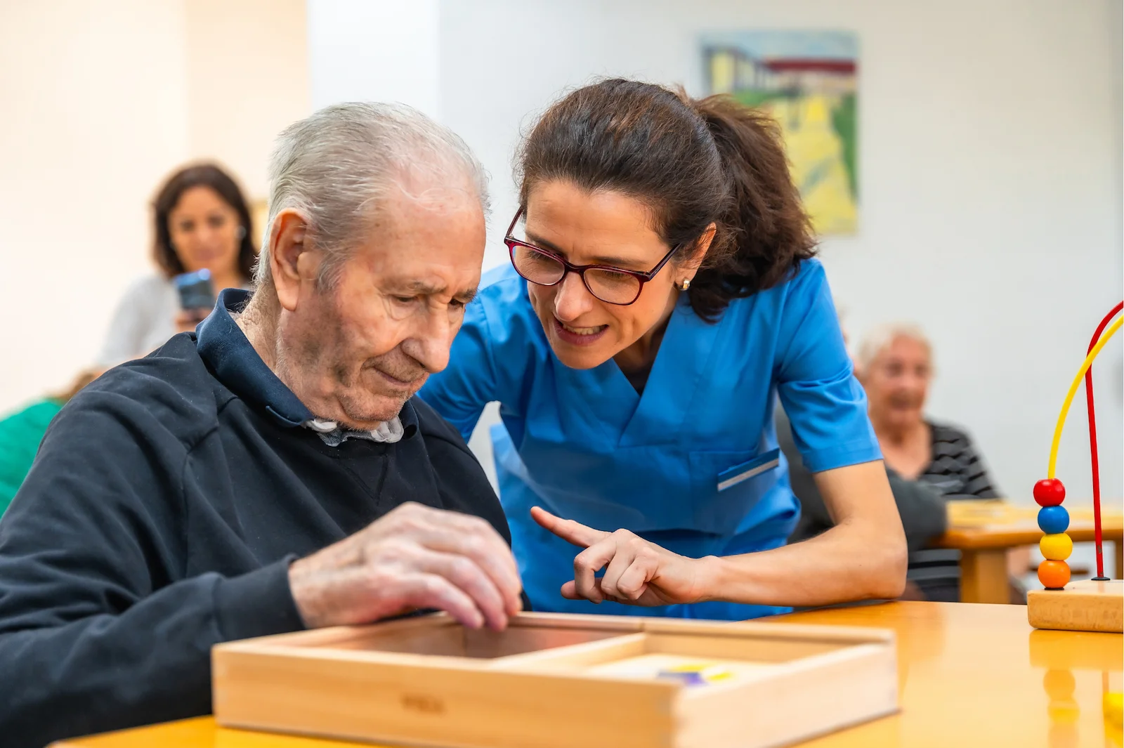 Therapist guiding senior through cognitive activity session