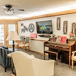 Alderbrook Village assisted living community in Arkansas City, KS, community gathering area with seating and a piano for entertainment