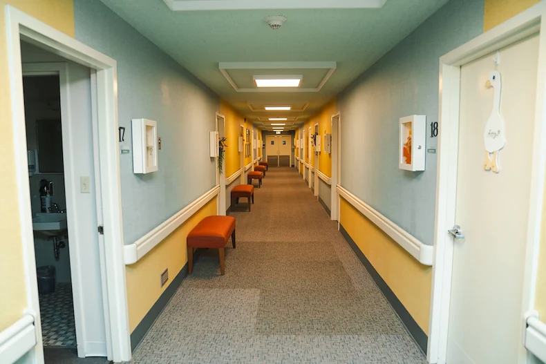 Wesley Manor Assisted Living Community offering assisted living and continuing care retirement community (CCRC) services in Louisville, KY, hallway with blue on the upper portion of the walls and yellow on the lower portion