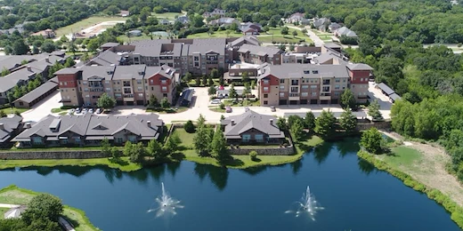 Active adult living and independent living at Watercrest at Mansfield in Mansfield, TX, community exterior with a pond in view