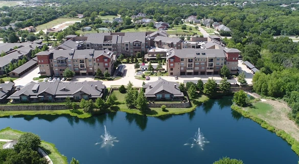 Active adult living and independent living at Watercrest at Mansfield in Mansfield, TX, community exterior with a pond in view