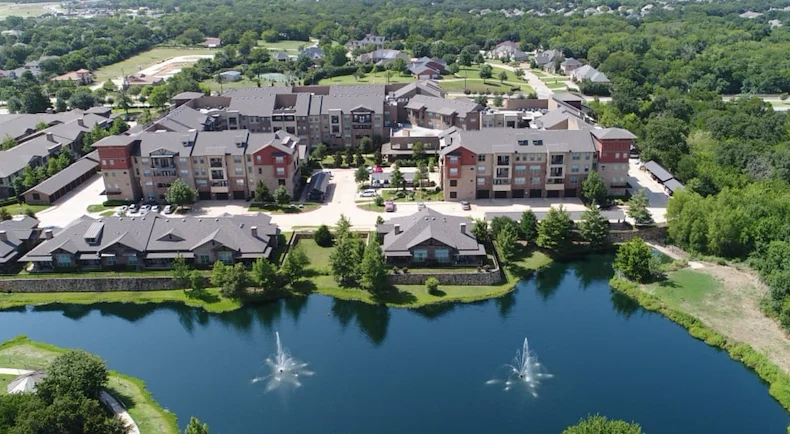 Active adult living and independent living at Watercrest at Mansfield in Mansfield, TX, community exterior with a pond in view