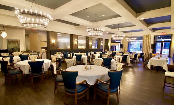 Watermere at Frisco senior living community offering active adult living and independent living in Frisco, TX, featuring a formal dining room with elegant lighting, upscale finishes, and refined décor