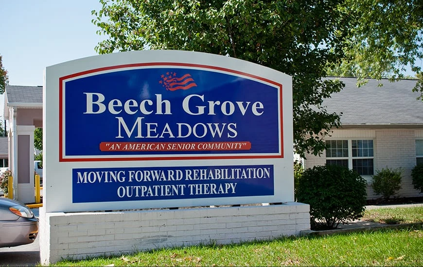 Independent living and assisted living at Beech Grove Meadows Assisted Living in Beech Grove, IN, front exterior welcome sign that says "Beech Grove Meadows 'An American Senior Community' Moving Forward Rehabilitation Outpatient Therapy"