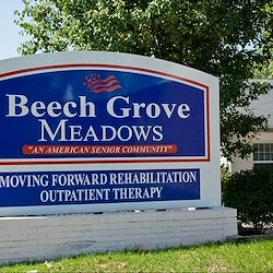 Independent living and assisted living at Beech Grove Meadows Assisted Living in Beech Grove, IN, front exterior welcome sign that says "Beech Grove Meadows 'An American Senior Community' Moving Forward Rehabilitation Outpatient Therapy"