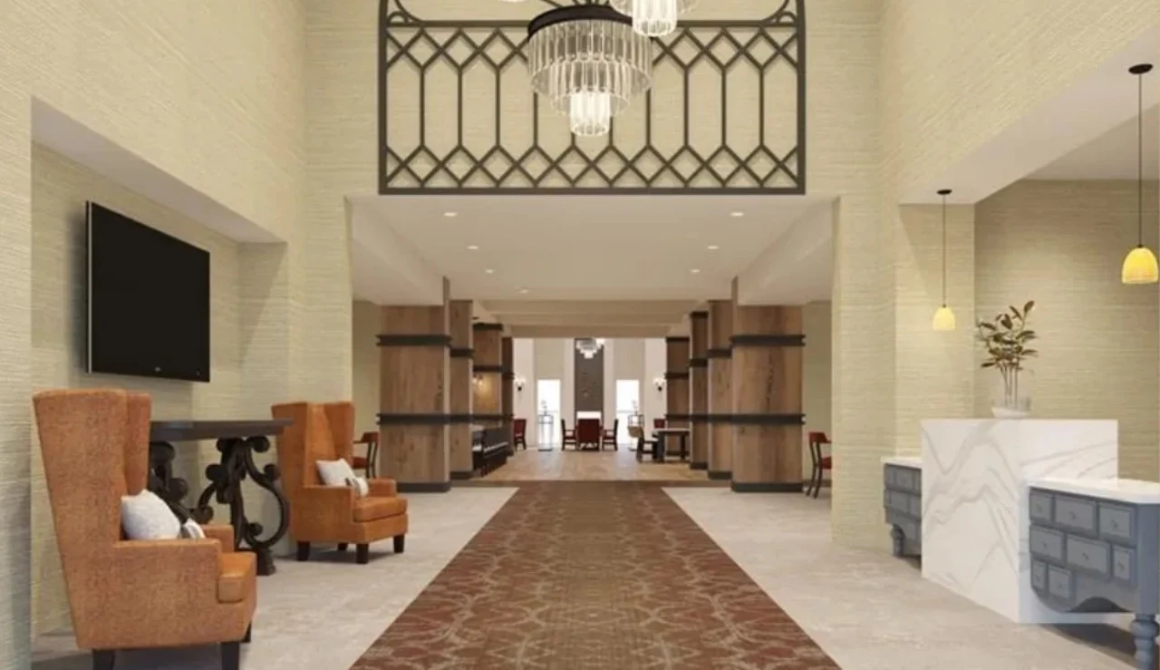 Watermere at Flower Mound senior living community offering active adult living and independent living in Flower Mound, TX, featuring a welcoming lobby with a front desk and orange chairs