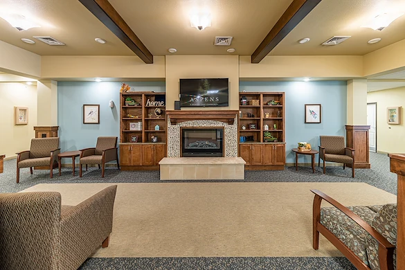 Aspens at Fort Collins Senior Living, senior living community offering assisted living, memory care, and respite care in Fort Collins, CO, common space by a fireplace