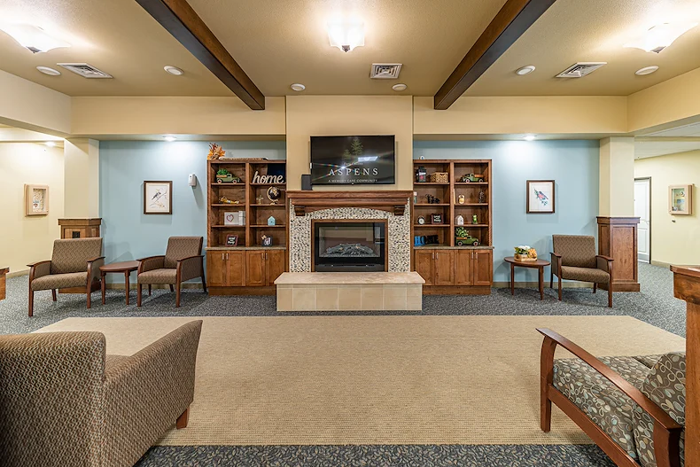 Aspens at Fort Collins Senior Living, senior living community offering assisted living, memory care, and respite care in Fort Collins, CO, common space by a fireplace