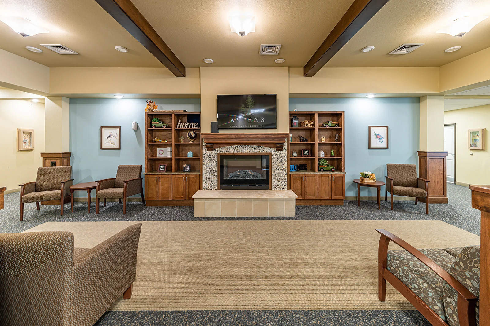 Aspens at Fort Collins Senior Living, senior living community offering assisted living, memory care, and respite care in Fort Collins, CO, common space by a fireplace