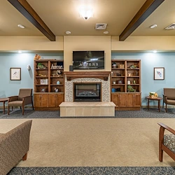 Aspens at Fort Collins Senior Living, senior living community offering assisted living, memory care, and respite care in Fort Collins, CO, common space by a fireplace