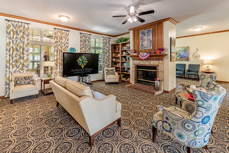 Ashbrook Village senior living community offering independent living, assisted living, and memory care in Duncan, OK, community lounging area by a fireplace