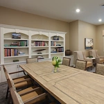 Liana of Sarasota senior living community offering assisted living and memory care in Sarasota, FL, community lounging room featuring a large table and comfortable chairs—ideal for socializing or relaxing