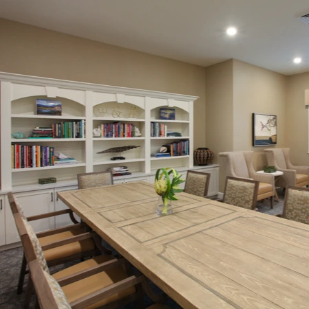 Liana of Sarasota senior living community offering assisted living and memory care in Sarasota, FL, community lounging room featuring a large table and comfortable chairs—ideal for socializing or relaxing
