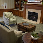 Allisonville Meadows Assisted Living offering assisted living, memory care, and respite care in Fishers, IN, lounge area by a fireplace