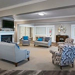 American House Dearborn Heights, senior living community offering independent living and respite care in Dearborn Heights, MI, community living room with seating by a fireplace