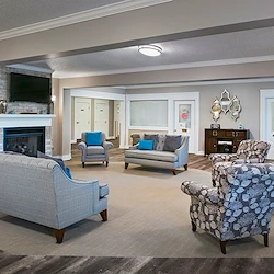 American House Dearborn Heights, senior living community offering independent living and respite care in Dearborn Heights, MI, community living room with seating by a fireplace