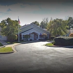 Exterior view of Charter Senior Living of Hazel Crest in Hazel Crest, IL, featuring a welcoming building with a circular drive drop-off area, offering assisted living and memory care.