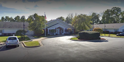 Exterior view of Charter Senior Living of Hazel Crest in Hazel Crest, IL, featuring a welcoming building with a circular drive drop-off area, offering assisted living and memory care.