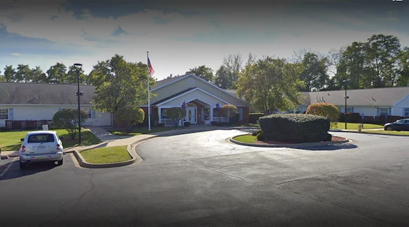 Exterior view of Charter Senior Living of Hazel Crest in Hazel Crest, IL, featuring a welcoming building with a circular drive drop-off area, offering assisted living and memory care.