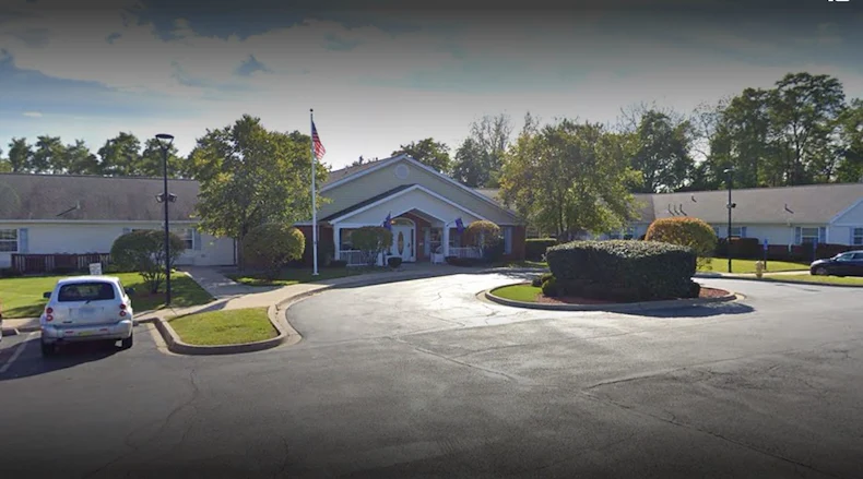 Exterior view of Charter Senior Living of Hazel Crest in Hazel Crest, IL, featuring a welcoming building with a circular drive drop-off area, offering assisted living and memory care.