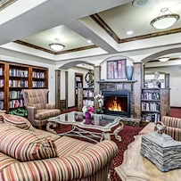 Alexis Estates Gracious Retirement Living by Hawthorn Senior Living, independent living in Allen, TX, sitting area by fireplace for socializing or reading