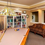 Westlake Woods by New Perspective senior living community offering assisted living in Erie, PA, activity room with bookshelves filled with books and a pool table for recreation