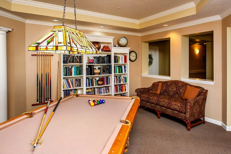 Westlake Woods by New Perspective senior living community offering assisted living in Erie, PA, activity room with bookshelves filled with books and a pool table for recreation