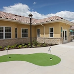 Liana of Venice senior living community offering assisted living and memory care in Venice, FL, exterior featuring a small putting green