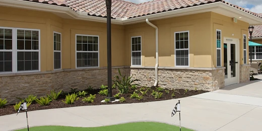 Liana of Venice senior living community offering assisted living and memory care in Venice, FL, exterior featuring a small putting green