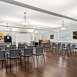 Avamere at Mountain Ridge senior living community offering assisted living, memory care, and respite care in South Ogden, UT, open activities room with chairs arranged for a group event and a kitchenette in the background