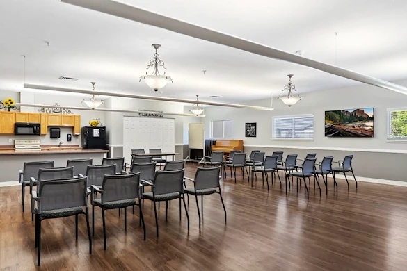 Avamere at Mountain Ridge senior living community offering assisted living, memory care, and respite care in South Ogden, UT, open activities room with chairs arranged for a group event and a kitchenette in the background