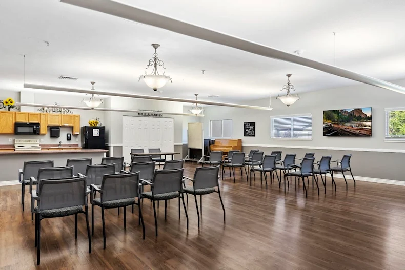 Avamere at Mountain Ridge senior living community offering assisted living, memory care, and respite care in South Ogden, UT, open activities room with chairs arranged for a group event and a kitchenette in the background