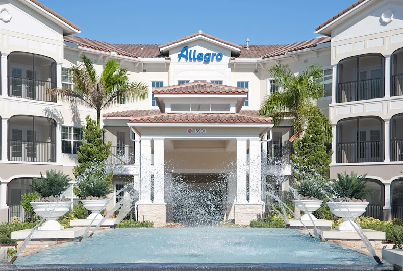 Allegro Parkland, senior living community offering independent living, assisted living, memory care, and respite care in Parkland, FL, front entrance with water feature