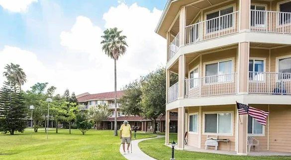Independent living, assisted living, memory care, and continuing care retirement community (CCRC) at Brook Ridge-The Gardens Retirement Community in Pharr, TX, rear exterior and outdoor walking path