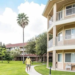 Independent living, assisted living, memory care, and continuing care retirement community (CCRC) at Brook Ridge-The Gardens Retirement Community in Pharr, TX, rear exterior and outdoor walking path